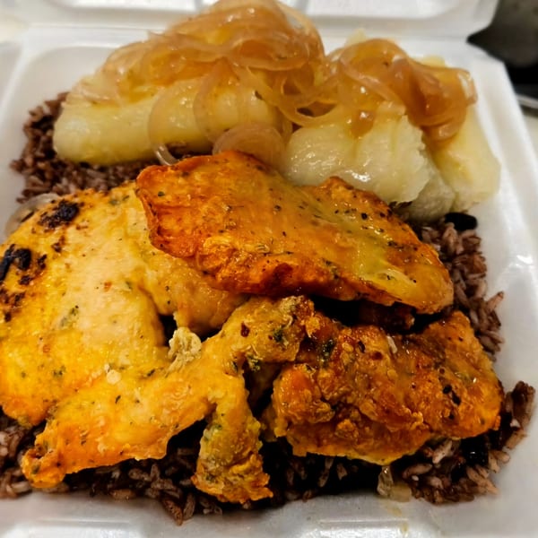 Mima's Cuban Cafe's chicken and yucca with onions over rice and beans in a takeout container.